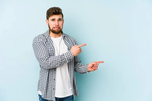 Young Caucasian Man Isolated Blue Background Shocked Pointing Index Fingers — Stock Photo, Image