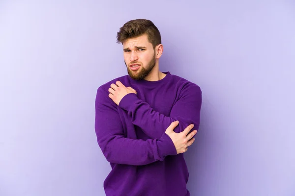 紫の背景に孤立した若い白人男性が肘をマッサージし 悪い動きの後に苦しんでいる — ストック写真