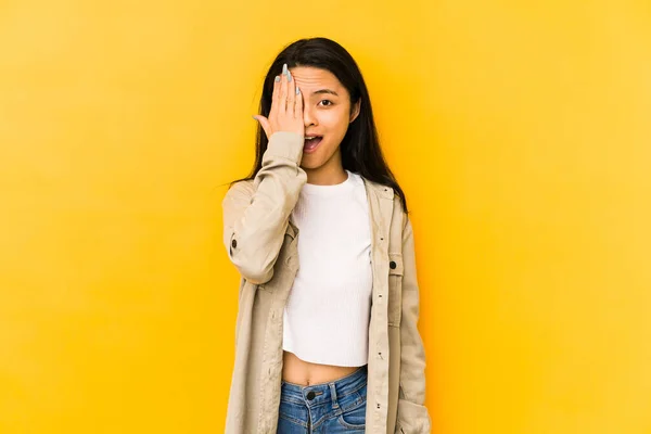 Joven Mujer China Aislada Sobre Fondo Amarillo Que Divierte Cubriendo —  Fotos de Stock