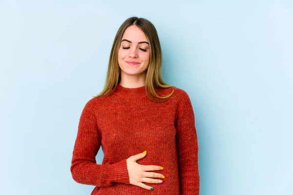 Jonge Blanke Vrouw Geïsoleerd Blauwe Achtergrond Raakt Buik Glimlacht Zachtjes — Stockfoto