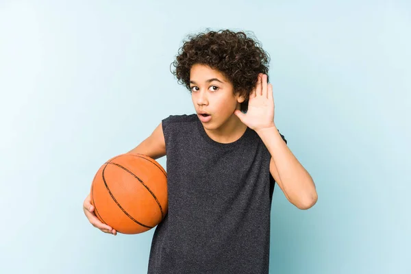 Ragazzo Che Gioca Basket Isolato Sfondo Blu Cercando Ascoltare Pettegolezzo — Foto Stock