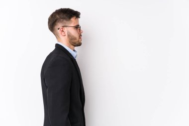 Beyaz arka planda poz veren beyaz tenli genç beyaz iş adamı soldan bakan beyaz tenli bir iş adamı..