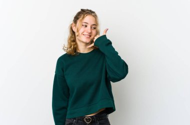 Beyaz arka plandaki genç beyaz kadın parmaklarıyla bir cep telefonu çağrısı hareketi gösteriyor..