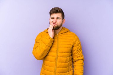 Mor arka planda izole edilmiş genç bir adam güçlü bir diş ağrısı, azıdişi ağrısı var..