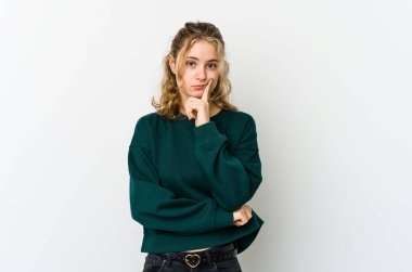 Beyaz sırtlı beyaz bir kadın şüpheli ve şüpheci bir ifadeyle yan bakıyor..