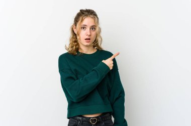 Beyaz sırtlı, beyaz saçlı genç bir kadın yan tarafı işaret ediyor.