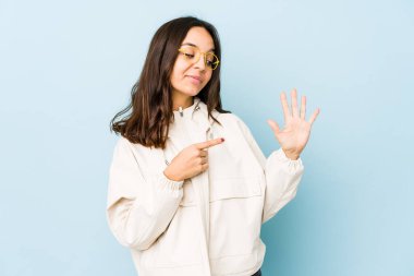 Genç, melez İspanyol kadın, tebessüm ederek beş numarayı parmaklarıyla izole etti..