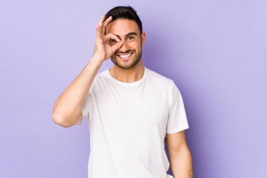 Mor arka planda izole edilmiş genç beyaz adam heyecanlı..