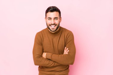 Pembe arka planda genç beyaz bir adam gülüyor ve eğleniyor..