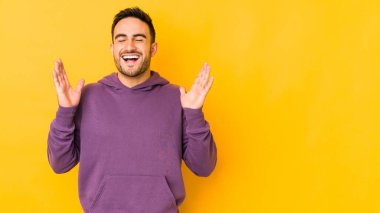 Sarı fırında izole edilmiş genç beyaz adam yüksek sesle gülüyor elini göğsüne koyuyor..