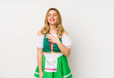 Aziz Patrick günü giysileri giyen genç bir kadın yalnız başına gülüyor, elini göğsüne koyuyor..