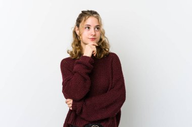 Beyaz sırtlı beyaz bir kadın şüpheli ve şüpheci bir ifadeyle yan bakıyor..