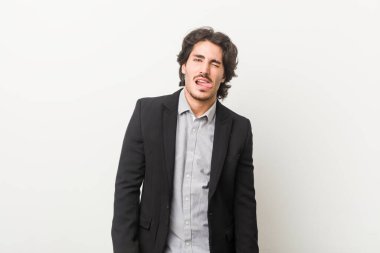 Genç bir iş adamı beyaz bir arka plana karşı komik ve dostane bir dil uzatıyor..