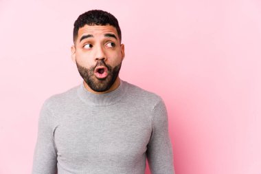 Pembe arka planda genç bir latin adam gördüğü bir şey yüzünden şoka uğruyor..