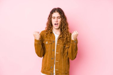 Uzun saçlı genç adam yalnız poz veriyor, gamsız ve heyecanlı. Zafer konsepti.