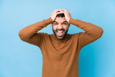 Mavi bir geçmişi olan genç bir latin adam neşeli bir şekilde el ele tutuşarak gülüyor. Mutluluk kavramı.