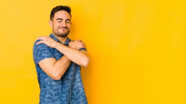 Kafkasyalı genç adam sarı fırında sarılıp, kaygısız ve mutlu bir şekilde sırıtıyor..