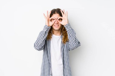 Genç, uzun saçlı adam yalnız poz veriyor. Gözlerinde işaret var.