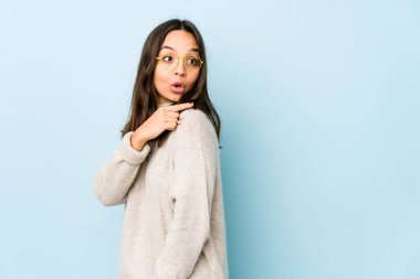 Genç, melez İspanyol bir kadın izole edilmiş, gülümseyen ve işaret eden boş alanda bir şey gösteriyor..