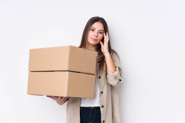 Genç beyaz kadın yeni bir eve taşınıyor. Parmağıyla tapınağı işaret ediyor. Düşünüyor, bir göreve odaklanıyor..