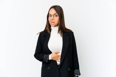 Genç melez iş kadını beyaz arka planda izole edilmiş karnına dokunuyor, nazikçe gülümsüyor, yemek yiyor ve tatmin oluyor..