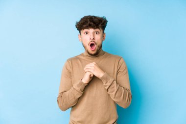 Genç Arap adam kendini izole ederek şans diliyor, şaşırmış ve ağzı açık bir şekilde önüne bakıyor..