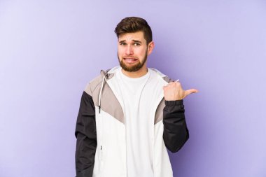 Mor arka planda izole edilmiş genç adam işaret parmağıyla fotokopi alanını göstererek şok oldu..