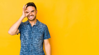 Kafkasyalı genç adam sarı fırında izole edilmiş. Heyecanlı. Göze göz hareketi yapıyor..