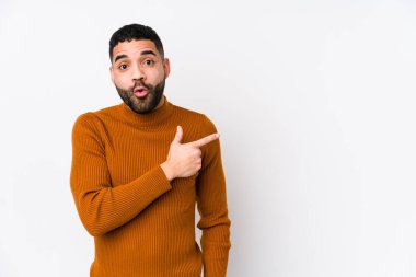 Beyaz bir arkaplanı olan genç bir latin adam yan tarafı gösteriyor.