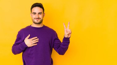 Kafkasyalı genç adam sarı fırında izole edilmiş yemin ediyor, elini göğsüne koyuyor..