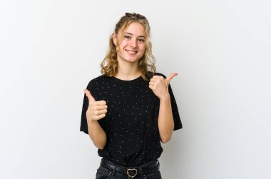 Beyaz arka planda genç beyaz kadın iki parmağını da kaldırıyor, gülümsüyor ve kendinden emin..