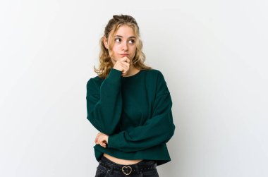 Beyaz sırtlı beyaz bir kadın şüpheli ve şüpheci bir ifadeyle yan bakıyor..