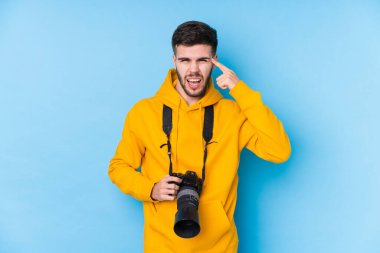 Kafkasyalı genç fotoğrafçı, işaret parmağıyla hayal kırıklığı jesti yapıyor..