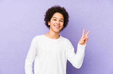 Afrika kökenli Amerikalı küçük çocuk zafer işareti gösteriyor ve gülümsüyor..