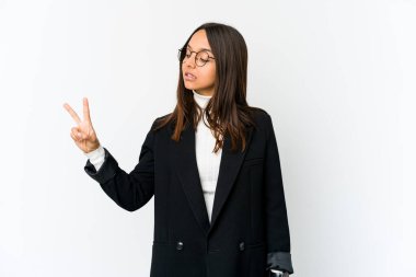 Genç melez iş kadını beyaz arka planda izole edilmiş neşeli ve kaygısız parmakları olan barış sembolü gösteriyor..