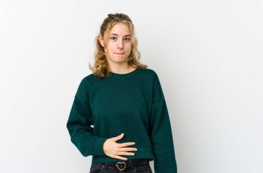 Beyaz sırtlı genç beyaz kadın karnına dokunuyor, nazikçe gülümsüyor, yemek yiyor ve tatmin oluyor..