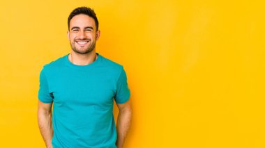 Kafkasyalı genç adam sarı fırında izole edilmiş. Kahkaha atıyor ve gözlerini kapıyor. Rahatlamış ve mutlu hissediyor..