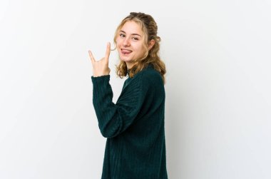 Beyaz arka plandaki genç beyaz kadın parmaklarıyla taş hareketi gösteriyor.