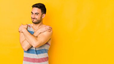 Kafkasyalı genç adam sarı fırında sarılıp, kaygısız ve mutlu bir şekilde sırıtıyor..