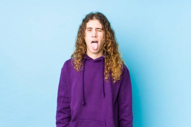 Uzun saçlı adam garip ve arkadaş canlısı poz veriyor..