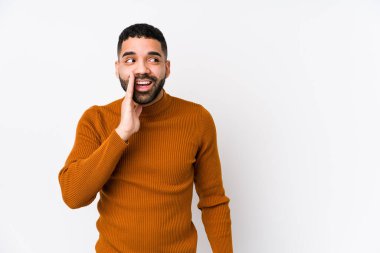 Beyaz arka planı olan genç bir latin adam gizli bir sıcak fren haberi veriyor ve kenara bakıyor.