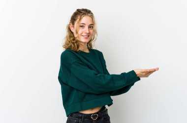 Beyaz arka plandaki genç beyaz kadın palmiye ağacında bir kopya alanı tutuyor..