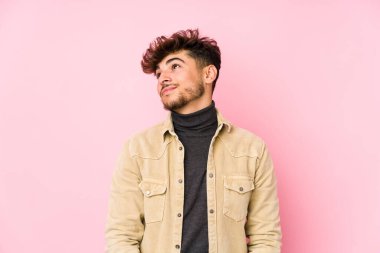 Arka planda poz veren genç Arap adam hedeflerine ve amaçlarına ulaşma hayali kuruyor.