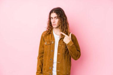 Genç, uzun saçlı, yalnız poz veren, seni parmağıyla işaret eden, sanki davet ediyormuş gibi..