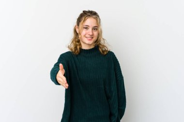 Beyaz arka planda genç beyaz bir kadın kameraya elini uzatarak selam veriyor..