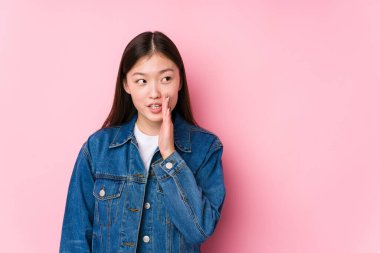 Pembe arka planda poz veren genç Çinli kadın gizli bir sıcak fren haberinin olduğunu söylüyor.