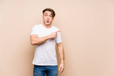 Kafkasyalı genç adam, yalıtılmış poz veriyor. Yan tarafı işaret ediyor.