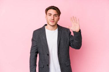 Kafkasyalı genç bir iş adamı yalnız poz veriyor. Beş numarayı parmaklarıyla gülümsüyor..