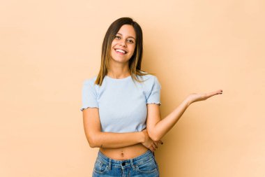 Bej arka planda izole edilmiş genç bir kadın bir avuç içinde fotokopi alanı ve belinde bir el daha olduğunu gösteriyor..