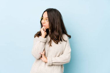 Latin kökenli genç bir kadın şüpheli ve şüpheci bir ifadeyle yanlamasına bakıyor..